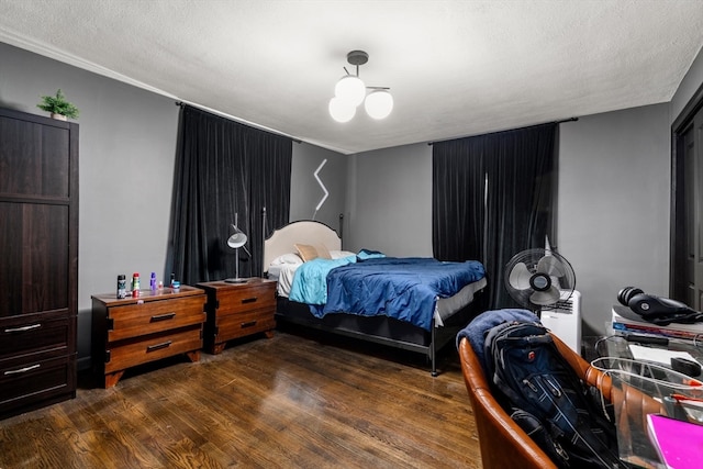 bedroom with a textured ceiling and dark hardwood / wood-style floors