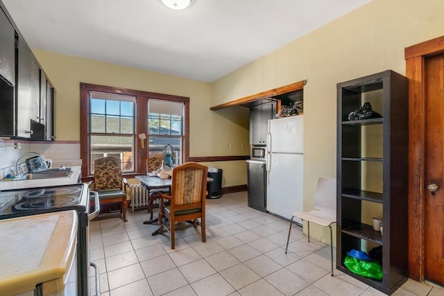 kitchen with range with electric stovetop, white refrigerator, backsplash, sink, and light tile patterned floors