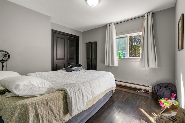 bedroom with baseboard heating and dark hardwood / wood-style floors