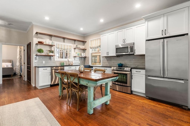 kitchen with appliances with stainless steel finishes, decorative backsplash, dark wood-style floors, open shelves, and dark countertops