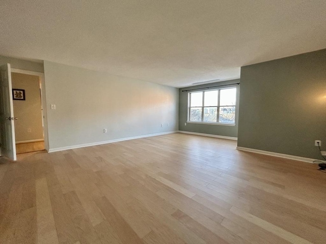 empty room featuring light wood-style flooring and baseboards