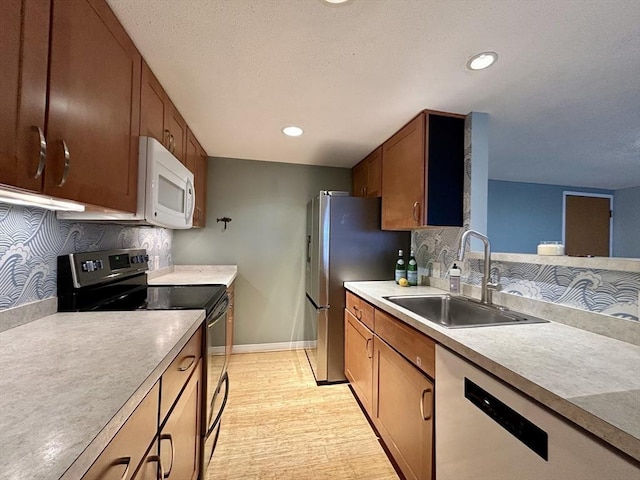 kitchen with white appliances, tasteful backsplash, light countertops, and a sink