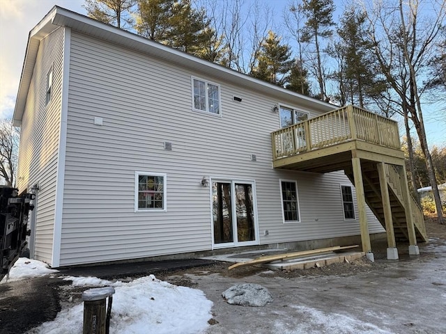 snow covered rear of property featuring a wooden deck