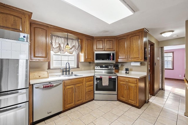 kitchen featuring sink, a wealth of natural light, hanging light fixtures, and appliances with stainless steel finishes