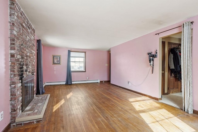 unfurnished living room featuring wood-type flooring, a fireplace, and a baseboard radiator