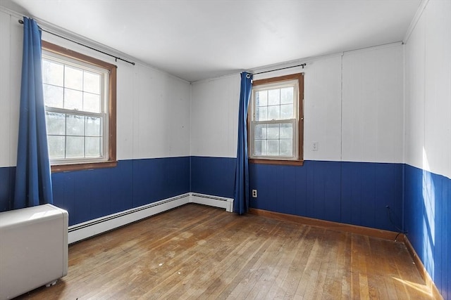 spare room featuring hardwood / wood-style floors and baseboard heating