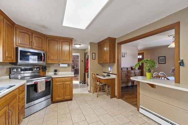 kitchen featuring stainless steel appliances, light tile patterned flooring, a baseboard heating unit, and sink