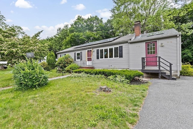 15 Leonard Rd, Sharon, MA 02067 - view of front facade with a chimney, roof mounted solar panels, and a front lawn
