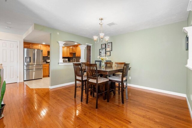 622 Hampton Way Unit 622, Abington, MA 02351 - dining space featuring decorative columns, arched walkways, light wood-style floors, a chandelier, and baseboards