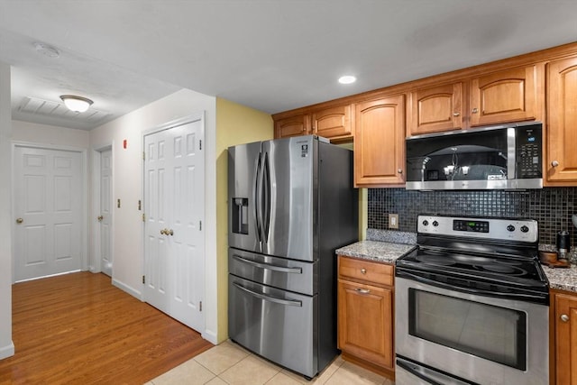 622 Hampton Way Unit 622, Abington, MA 02351 - kitchen with appliances with stainless steel finishes, light stone counters, backsplash, brown cabinetry, and recessed lighting
