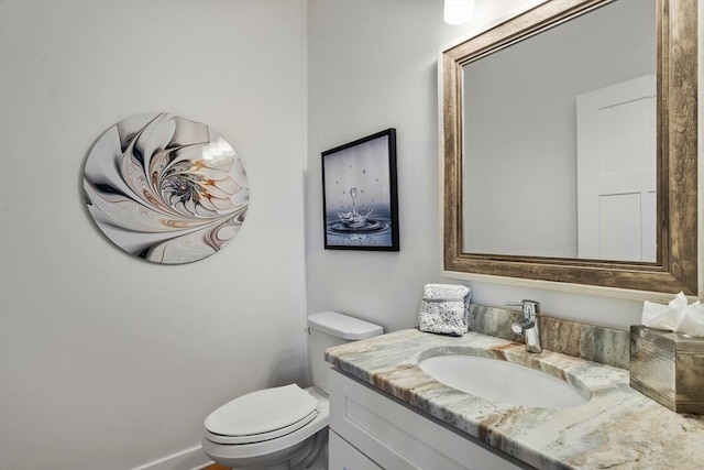 half bathroom with vanity and toilet