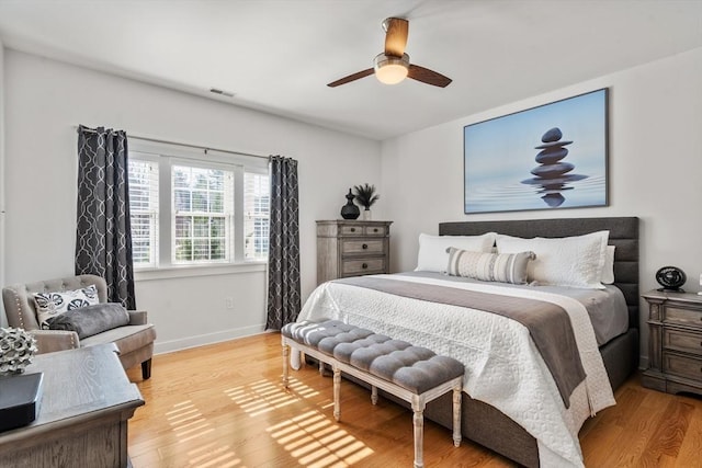 bedroom with a ceiling fan, baseboards, visible vents, and light wood-style floors