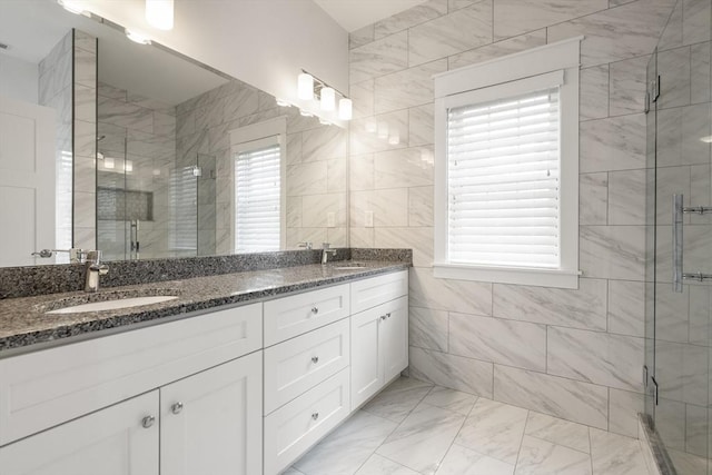 bathroom with a sink, marble finish floor, and a stall shower