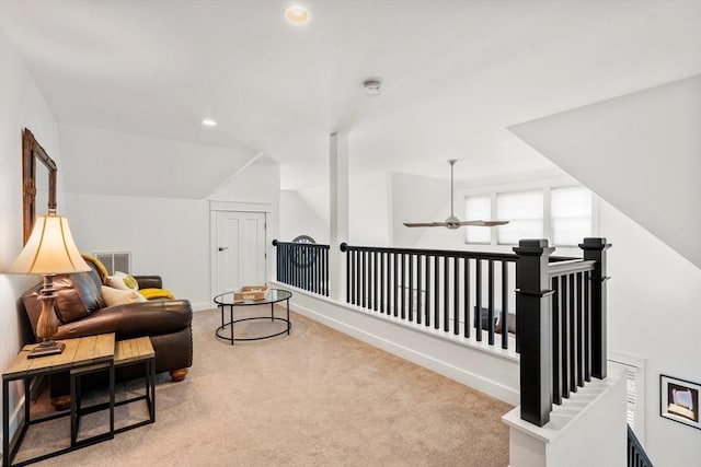 sitting room featuring ceiling fan, carpet, an upstairs landing, lofted ceiling, and visible vents