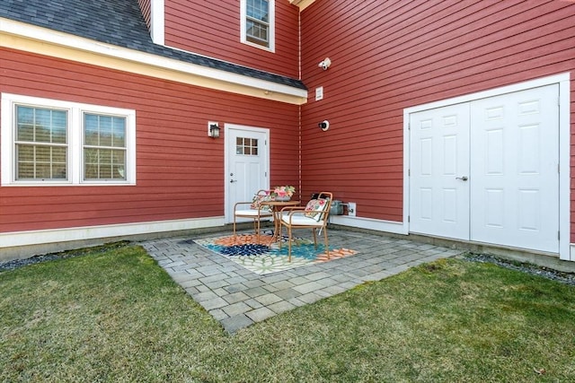 doorway to property featuring a yard and a patio