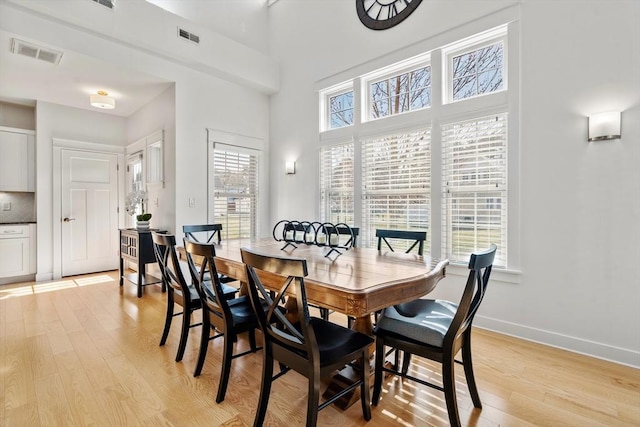 dining room with light wood-style floors, baseboards, and visible vents