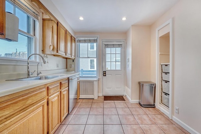 kitchen featuring sink, light tile patterned floors, stainless steel dishwasher, and light brown cabinets