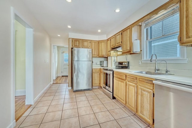 kitchen featuring sink, light brown cabinets, light tile patterned flooring, and appliances with stainless steel finishes