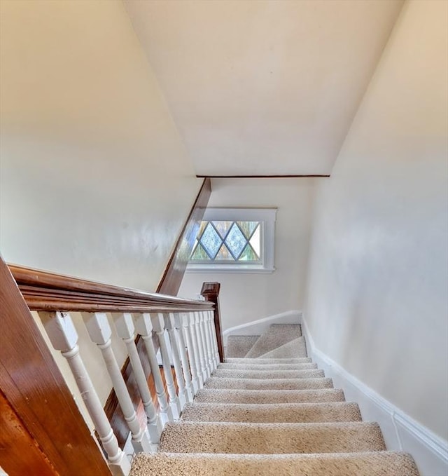 staircase with carpet and lofted ceiling