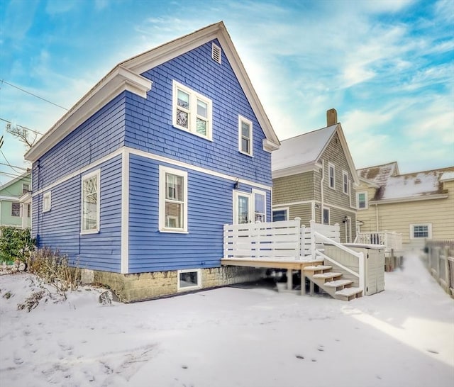 snow covered house featuring a deck