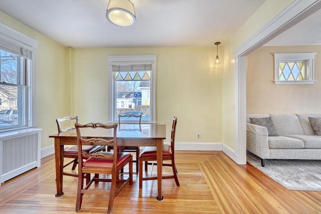 dining space featuring hardwood / wood-style flooring, plenty of natural light, and radiator