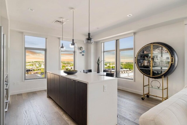 kitchen featuring light wood finished floors, modern cabinets, baseboards, and a kitchen island