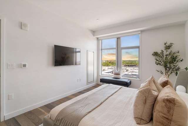 bedroom featuring wood finished floors and baseboards