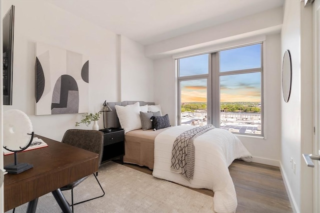 bedroom with wood finished floors and baseboards