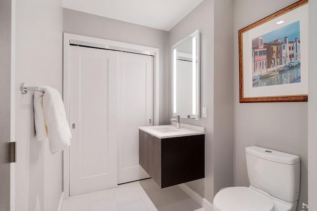 bathroom featuring toilet, baseboards, vanity, and tile patterned flooring