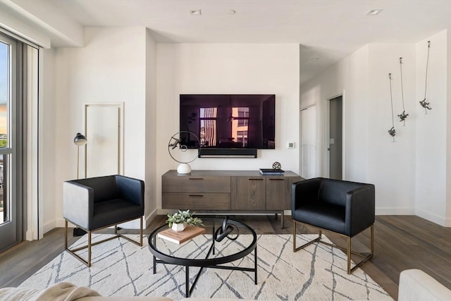 living area with wood finished floors, plenty of natural light, and baseboards