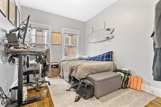 bedroom with wood finished floors and baseboards
