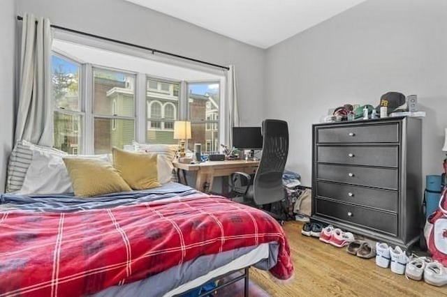 bedroom with multiple windows and wood finished floors