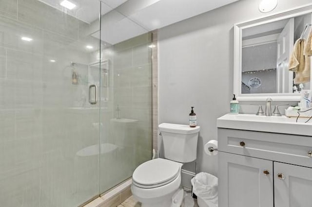 full bathroom featuring toilet, a shower stall, and vanity