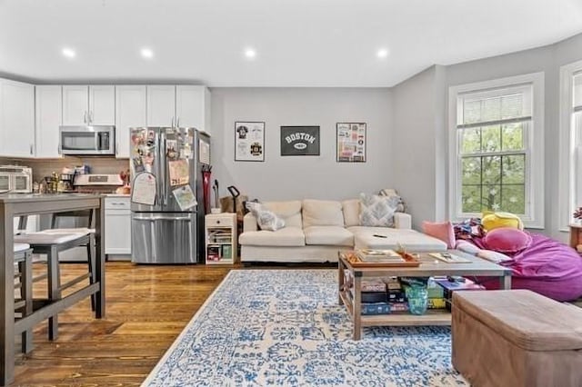 living room with dark wood-style floors and recessed lighting
