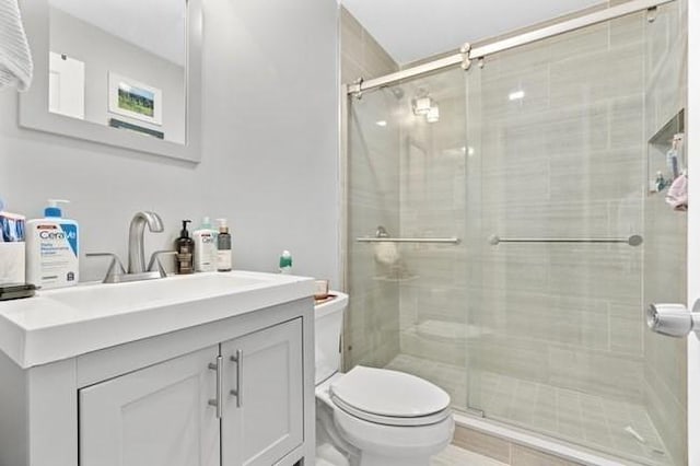 bathroom featuring toilet, a stall shower, and vanity