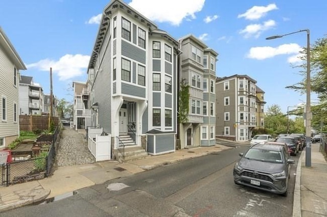 view of property with fence and central AC unit