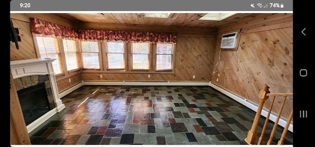 unfurnished dining area featuring baseboard heating, a stone fireplace, a wall unit AC, wood walls, and wood ceiling