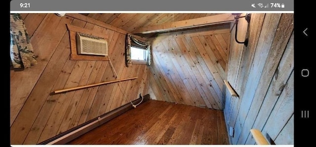 interior space with hardwood / wood-style flooring, a wall mounted AC, and wood walls