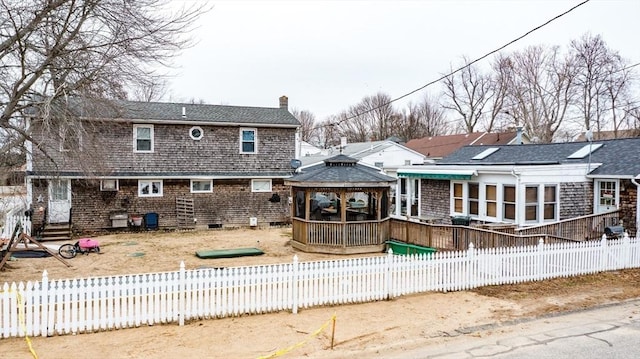 back of house with a gazebo, a sunroom, and a wooden deck