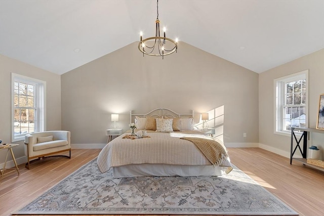 bedroom with light wood-style floors, multiple windows, baseboards, and an inviting chandelier