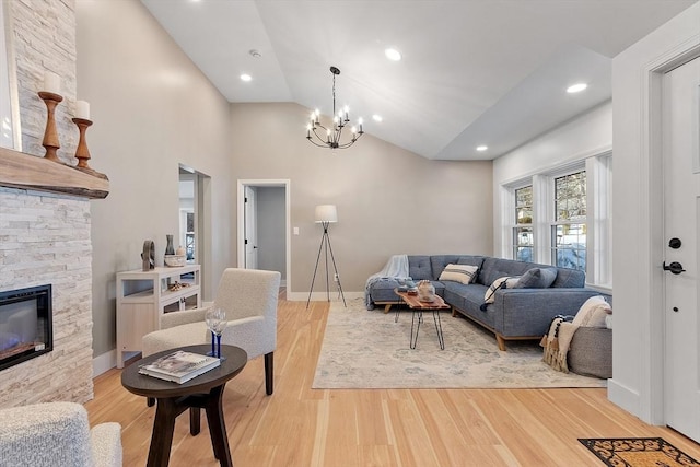 living room featuring a chandelier, a stone fireplace, recessed lighting, baseboards, and light wood-type flooring