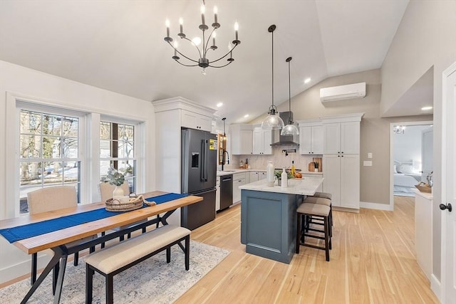 kitchen with high quality fridge, white cabinets, vaulted ceiling, a wall mounted AC, and dishwasher