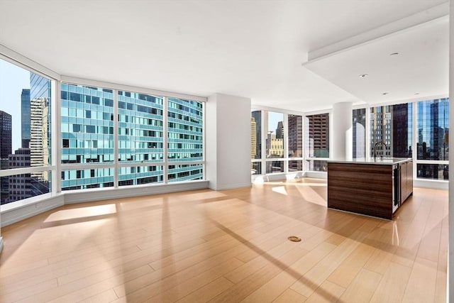 interior space with expansive windows, light wood-type flooring, and a wealth of natural light