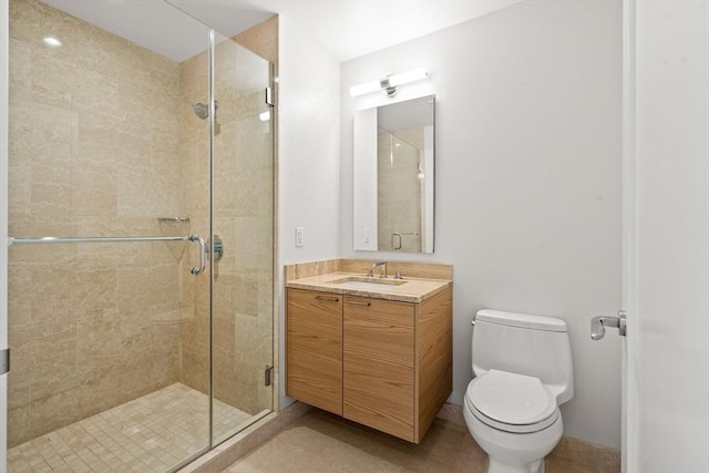 bathroom with vanity, toilet, and a shower with door