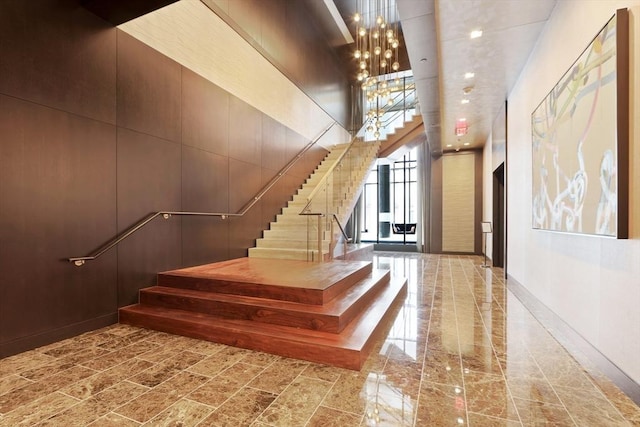 stairs featuring a towering ceiling and a chandelier