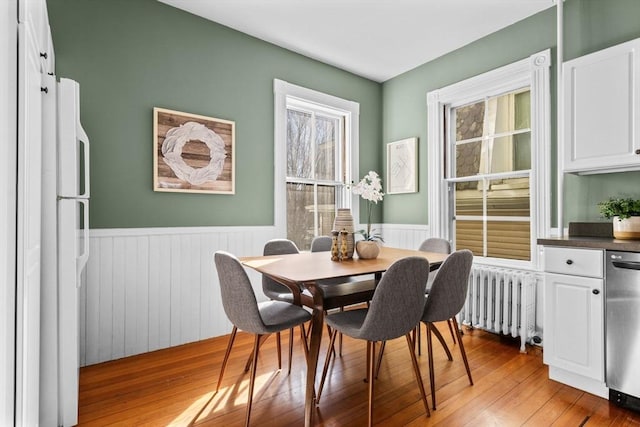 dining area featuring hardwood / wood-style flooring and radiator