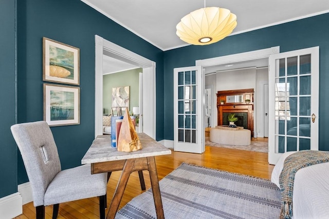 dining room featuring hardwood / wood-style flooring, ornamental molding, and french doors