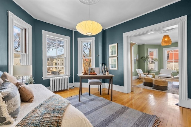 bedroom featuring wood-type flooring, ornamental molding, and radiator heating unit