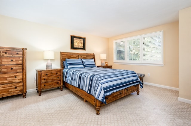 bedroom with light colored carpet and baseboards