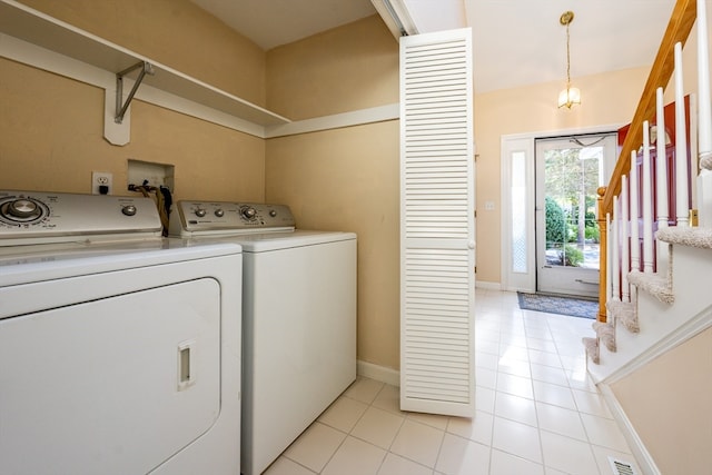 laundry area with light tile patterned floors, laundry area, baseboards, and washer and dryer